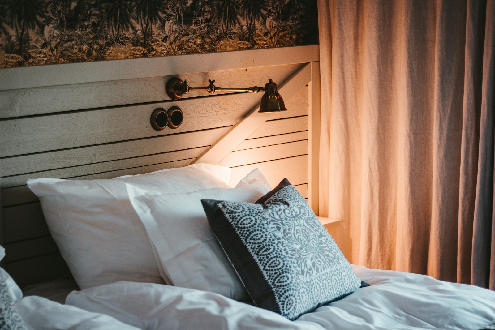 A quiet hotel bed in warm window light